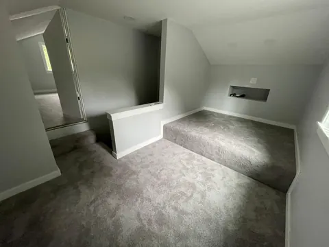 Stair opening with a painted half wall and wall niches in a converted attic in Kirkland, WA