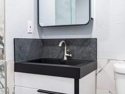 White vanity with an integrated black sink and slate-look backsplash in a Bellevue, WA bathroom