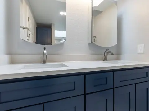 Navy shaker double vanity with two mirrors in a remodeled Redmond, WA bathroom