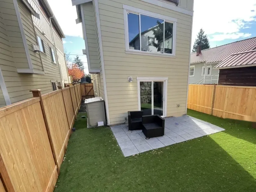 Finished back yard with artificial turf, a slab patio and new cedar fences