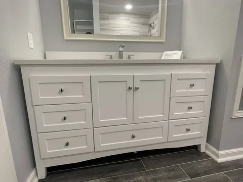 White double drawer vanity with a framed mirror and dark wood look tile floor in a Federal Way, WA basement bathroom