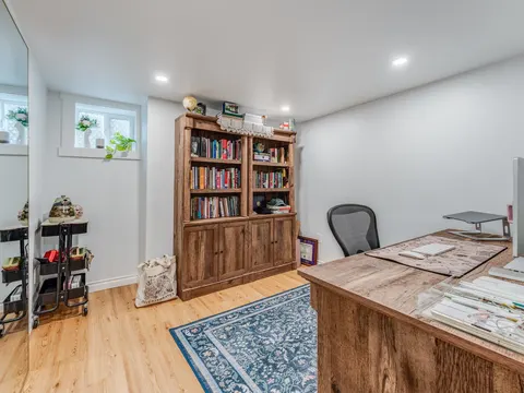Finished basement home office with a wood desk and bookcase in Seattle, WA