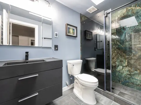 Black floating vanity and a green stone look shower in Everett, WA