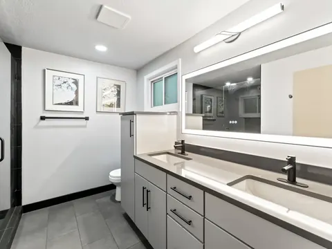 Gray double vanity with a lit mirror in a remodeled bathroom in Kirkland, WA
