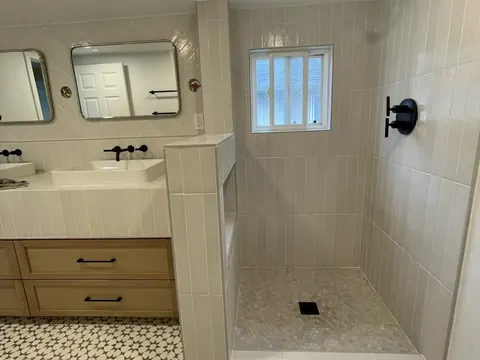 Double vanity with vessel sinks and a tiled walk in shower in Seattle, WA