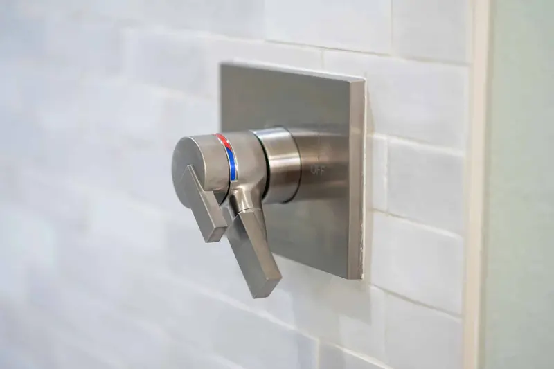 Brushed nickel shower valve trim set in light handmade-look tile