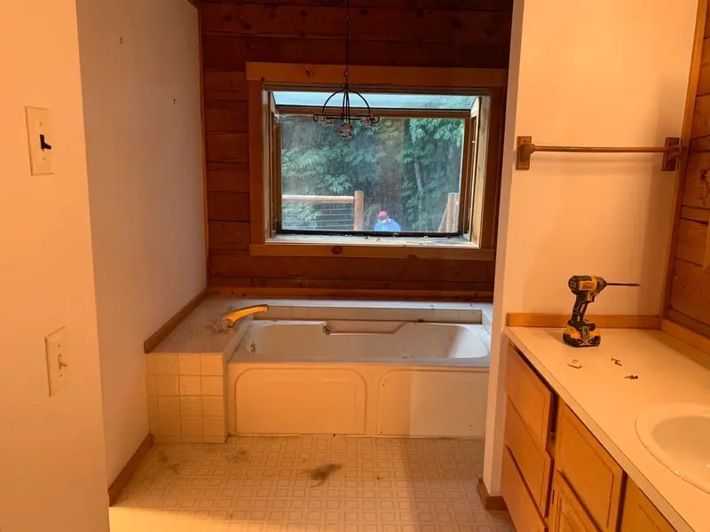 Old tub deck cleared out under the window during the bathroom remodel