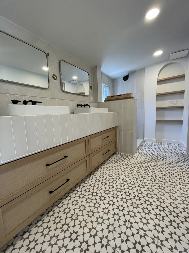Oak vanity drawers with black pulls under a white tile top