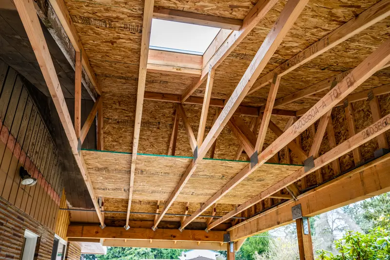 Close view of carport trusses framed around a skylight opening