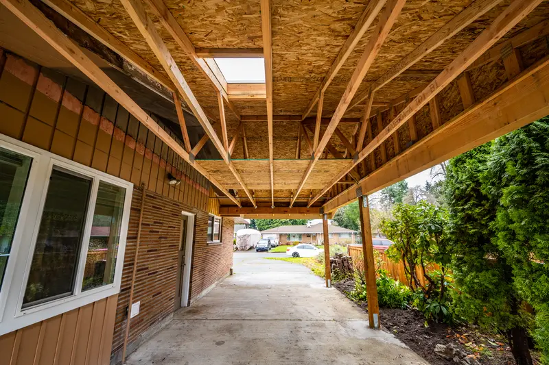 Underside of the new carport with open wood trusses, roof sheathing and a skylight, video thumbnail