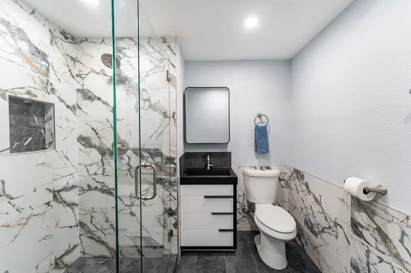 Bathroom remodel in Bellevue by Volcano Builders, marble tile shower and black vanity