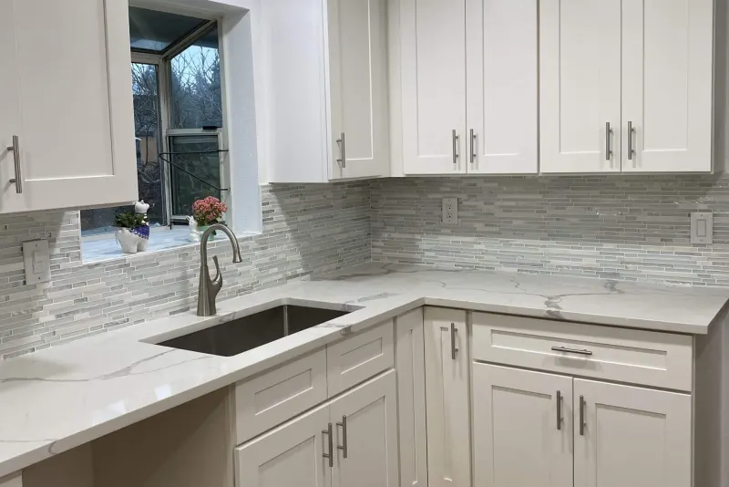 White shaker cabinets, white counters and a glass mosaic backsplash in a Snohomish kitchen remodel by Volcano Builders