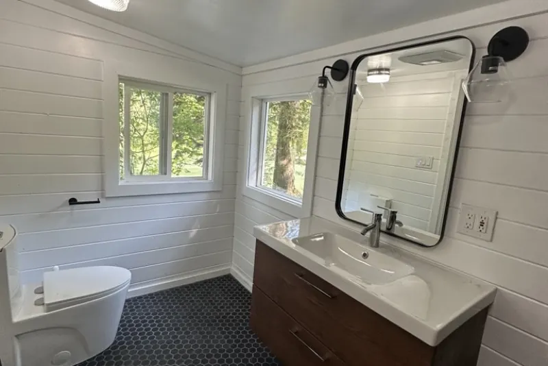 Bathroom with white shiplap walls, a walnut vanity and forest views, from a Gold Bar remodel by Volcano Builders