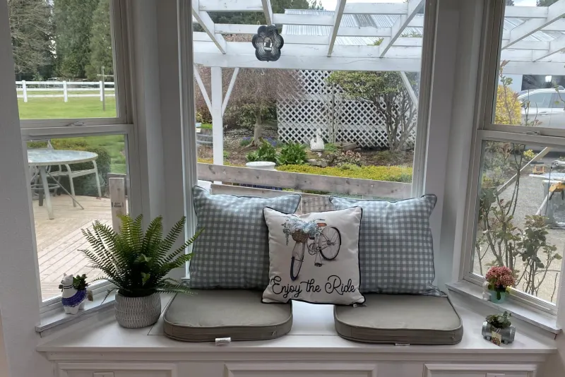 Built-in kitchen window seat with paneled base and bay windows over a garden, from a Snohomish kitchen remodel by Volcano Builders