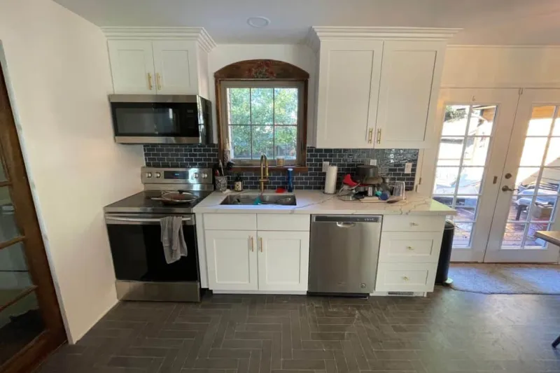 White shaker kitchen with a navy subway tile backsplash, from a kitchen remodel in Edmonds by Volcano Builders