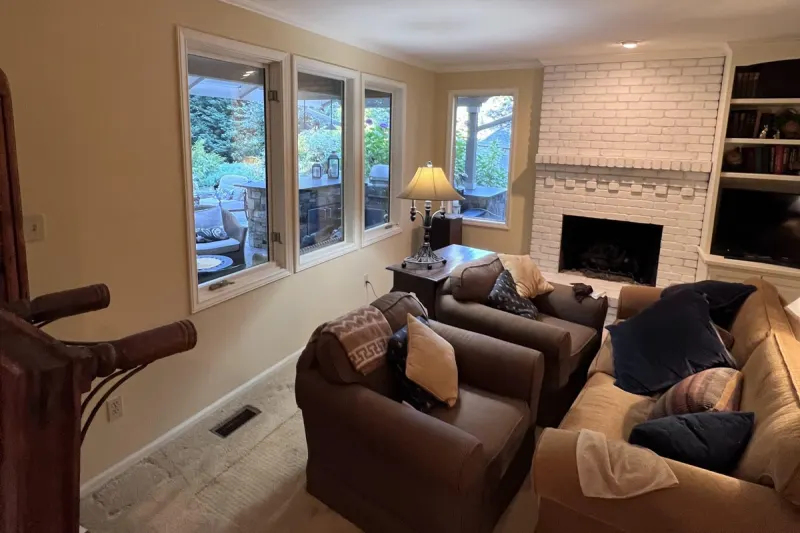 Living room with a white painted brick fireplace, built-in shelves and a row of garden windows, from a Sammamish living room remodel by Volcano Builders