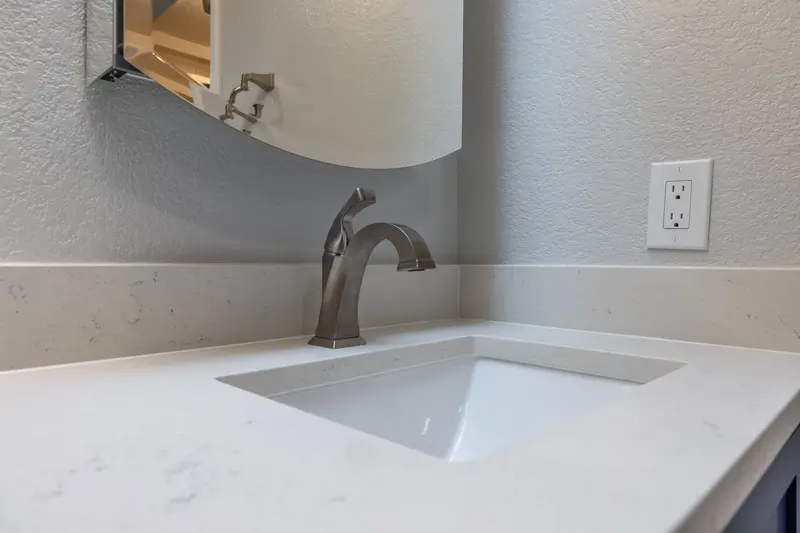 White quartz vanity top with an undermount sink and brushed nickel faucet from a Redmond bathroom remodel by Volcano Builders