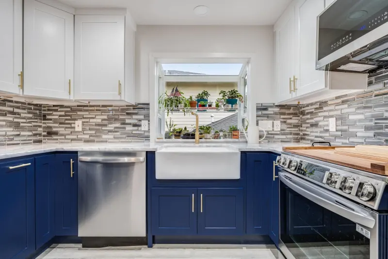 Kitchen remodel in Lynnwood by Volcano Builders with navy lower cabinets, white uppers and a farmhouse sink