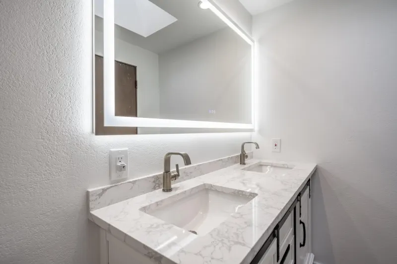 Marble topped bathroom vanity with a backlit mirror, from a Tulalip Bay bathroom remodel by Volcano Builders