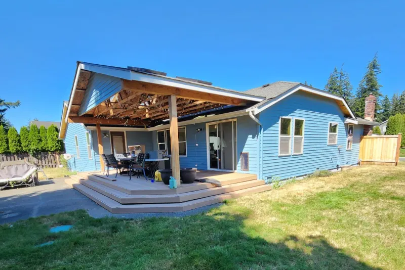 Blue painted house with a covered patio after an exterior painting job in Marysville by Volcano Builders