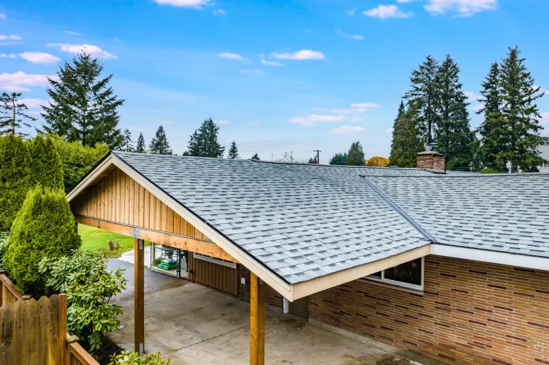 New shingle roof and a cedar gabled carport over a brick rambler, from an Auburn remodel by Volcano Builders