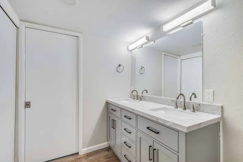 Double vanity with gray shaker drawers and a white quartz top in a Renton condo bathroom remodeled by Volcano Builders