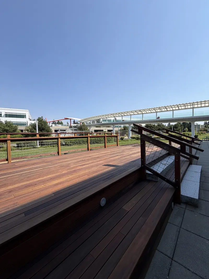 Refinished deck steps with a railing and bench seating along the side of the platform