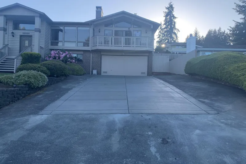 New concrete driveway with saw cut control joints leading to a two car garage in Bothell, WA