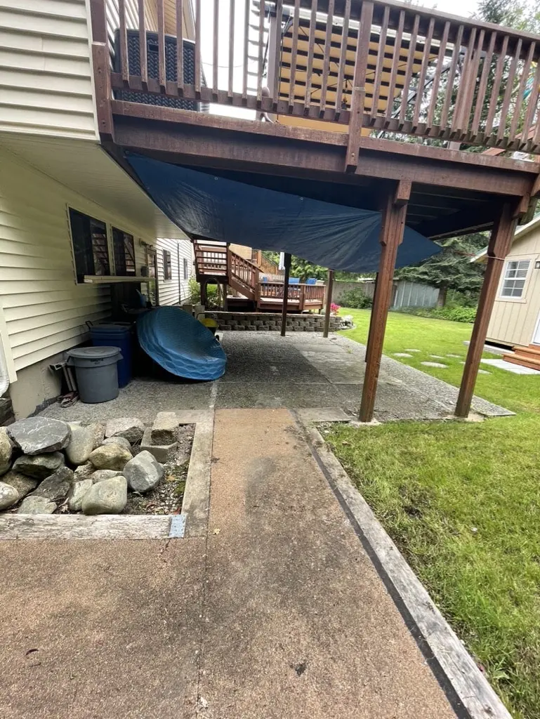 Narrow old path with a river rock edge along the side of a house before the new walkway