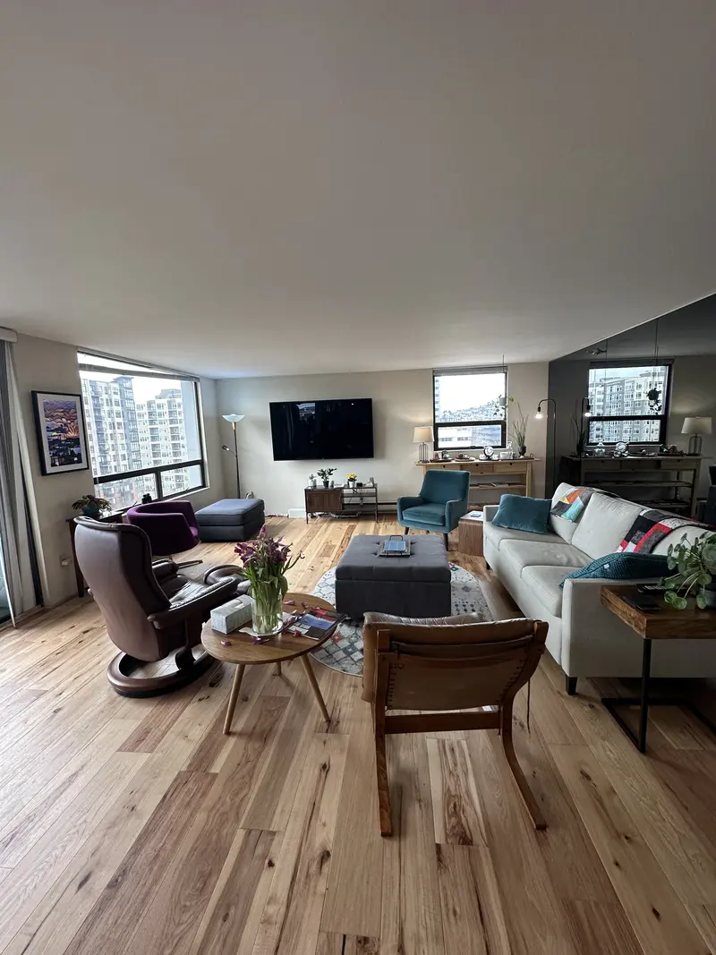 Condo living room with a sofa, chairs and a rug on the new wood floor