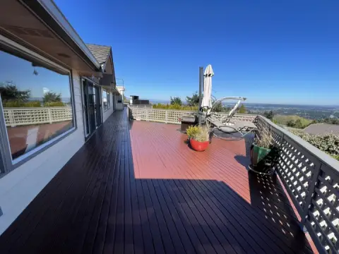 Refinished deck with dark and red stain and a lattice railing above a view in Bellevue, WA