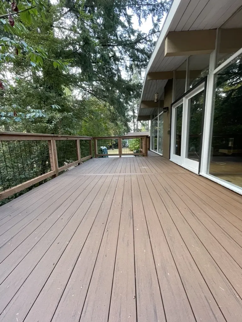 Rebuilt deck beside a row of windows with the railing running to the far end