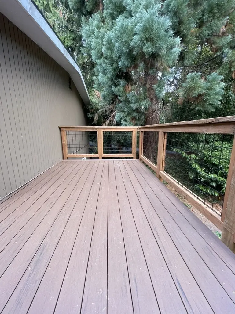 End of the rebuilt deck where the railing meets the house wall
