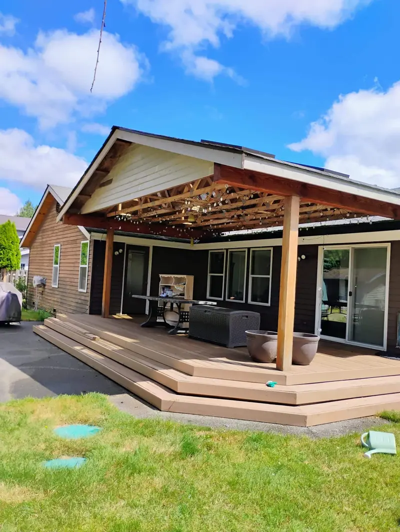 Back of the brown house with a wood patio cover over a composite deck