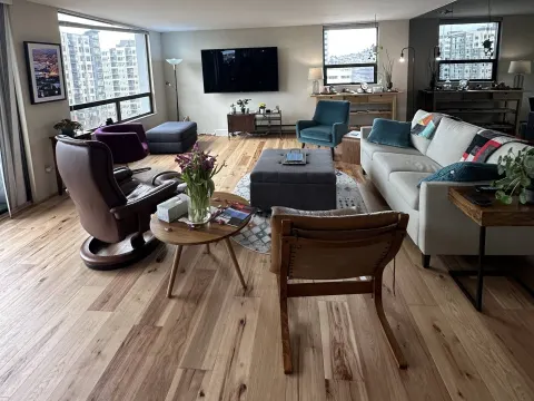 Light plank flooring across an open living room with city views in Seattle, WA