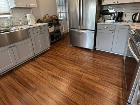 Warm brown wood look laminate running through a gray shaker kitchen in Seattle, WA