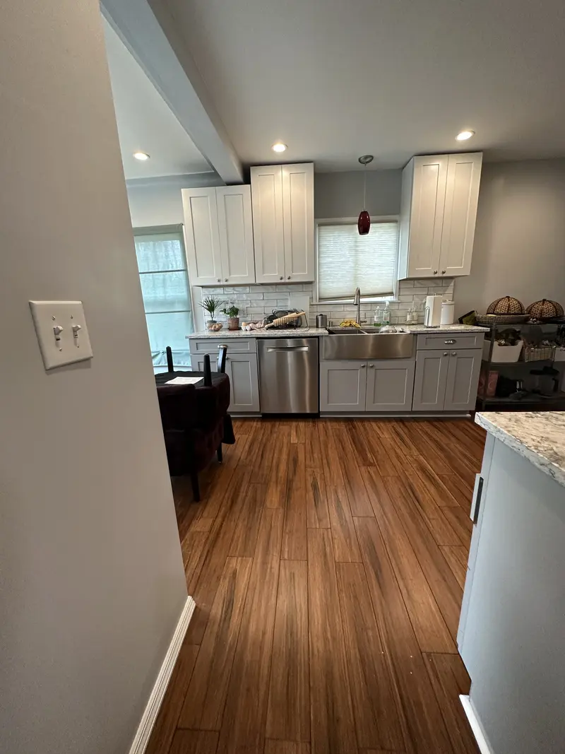 Looking from the dining area into the kitchen across a continuous plank floor