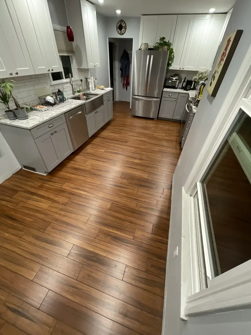 Long view down the kitchen cabinets with the plank floor reaching the far wall