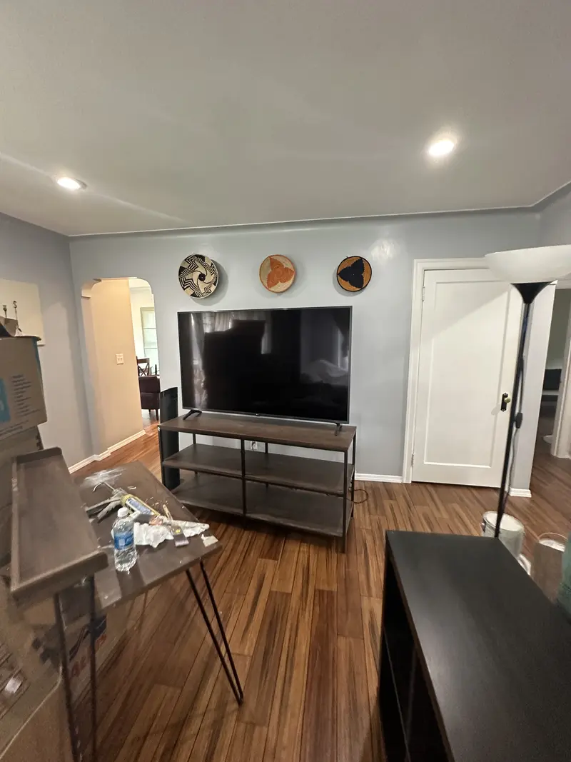 Living room with the plank floor, a television console and an arched opening