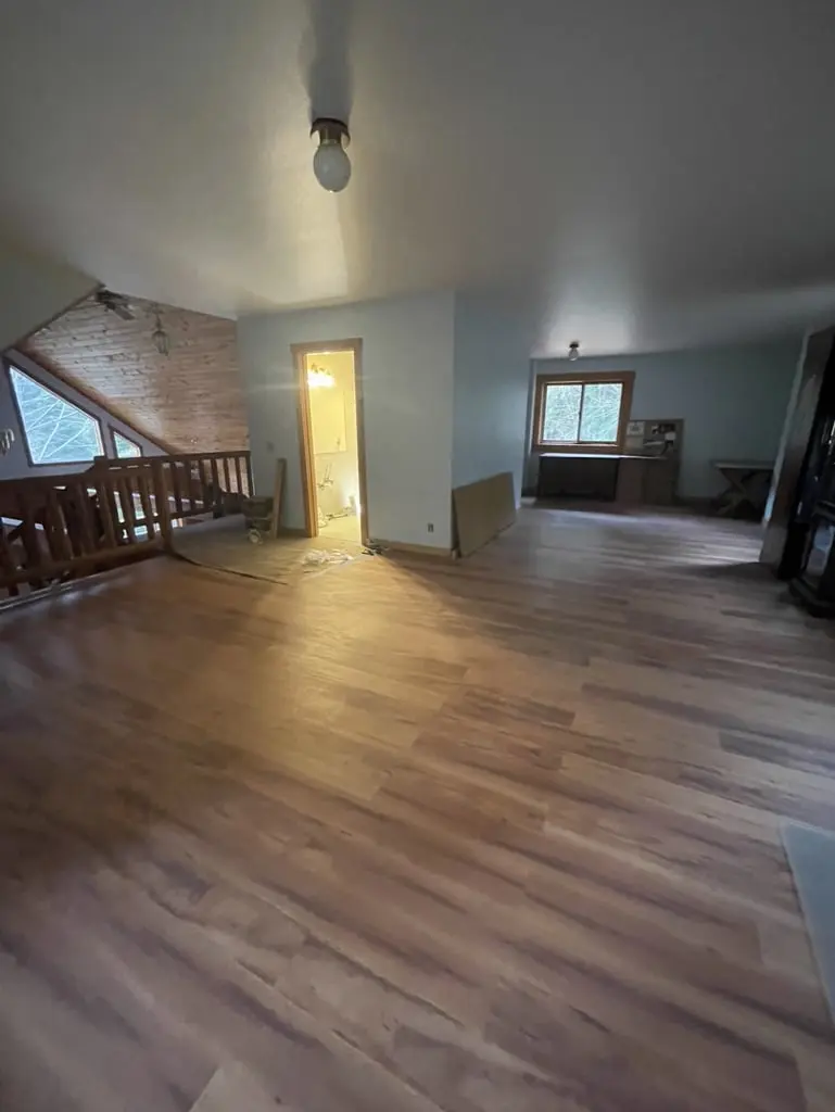Upstairs room with the new plank floor running toward the loft railing
