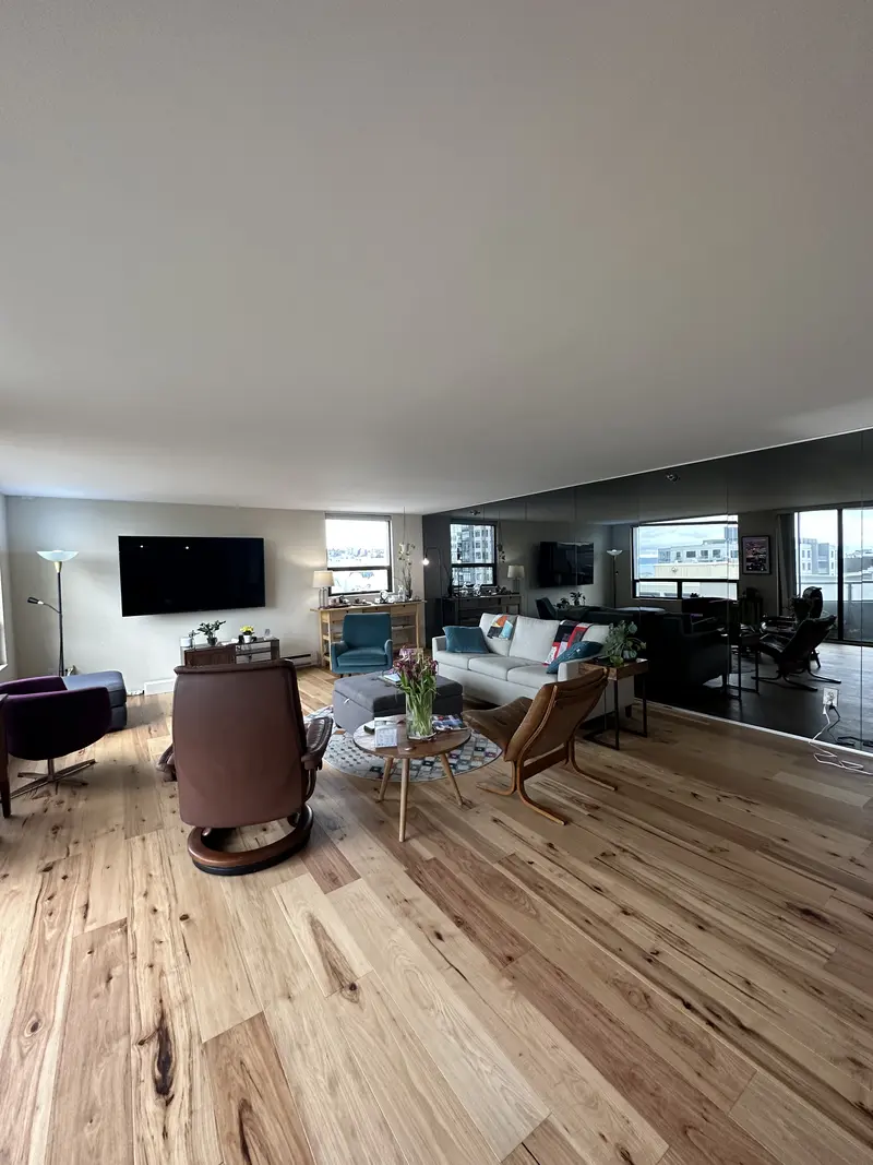 Condo living room on the new wood floor, looking toward the dining side and a window