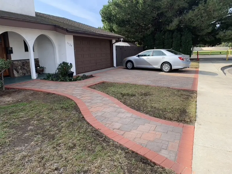 Curved paver walk with a red border leading to an arched front porch