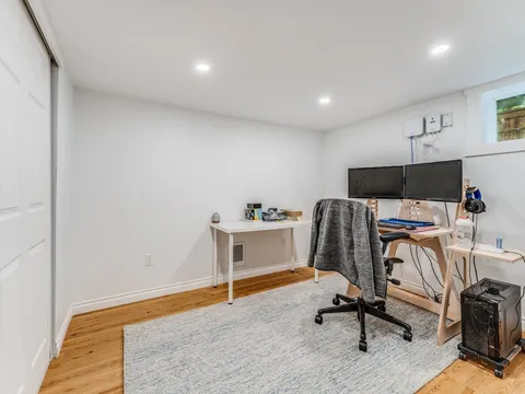 Basement home office with oak flooring, recessed lights and a daylight window in Seattle, WA