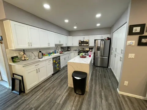 White shaker kitchen with a waterfall island and stainless appliances in Redmond, WA