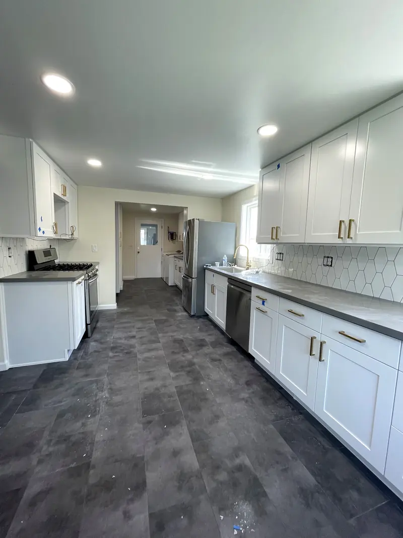 Galley kitchen with a stainless gas range on one side and the sink run on the other