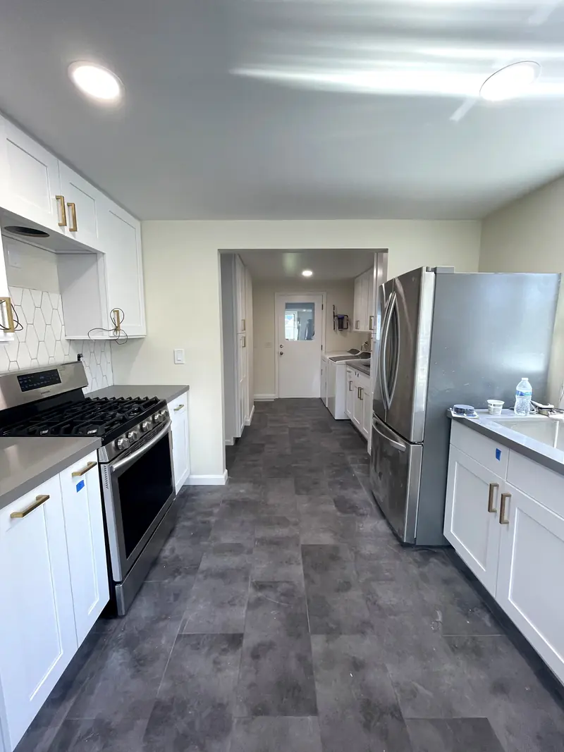 Kitchen range wall with a French door refrigerator beside the opening to the laundry hall