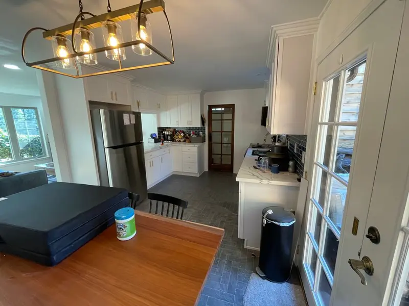 View from the dining table into the remodeled kitchen with a pendant light overhead