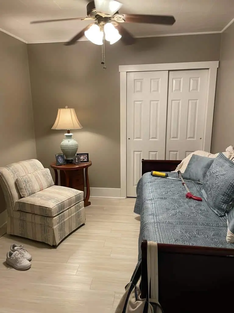 Room with gray walls, a two-door closet, an armchair and a daybed before the remodel