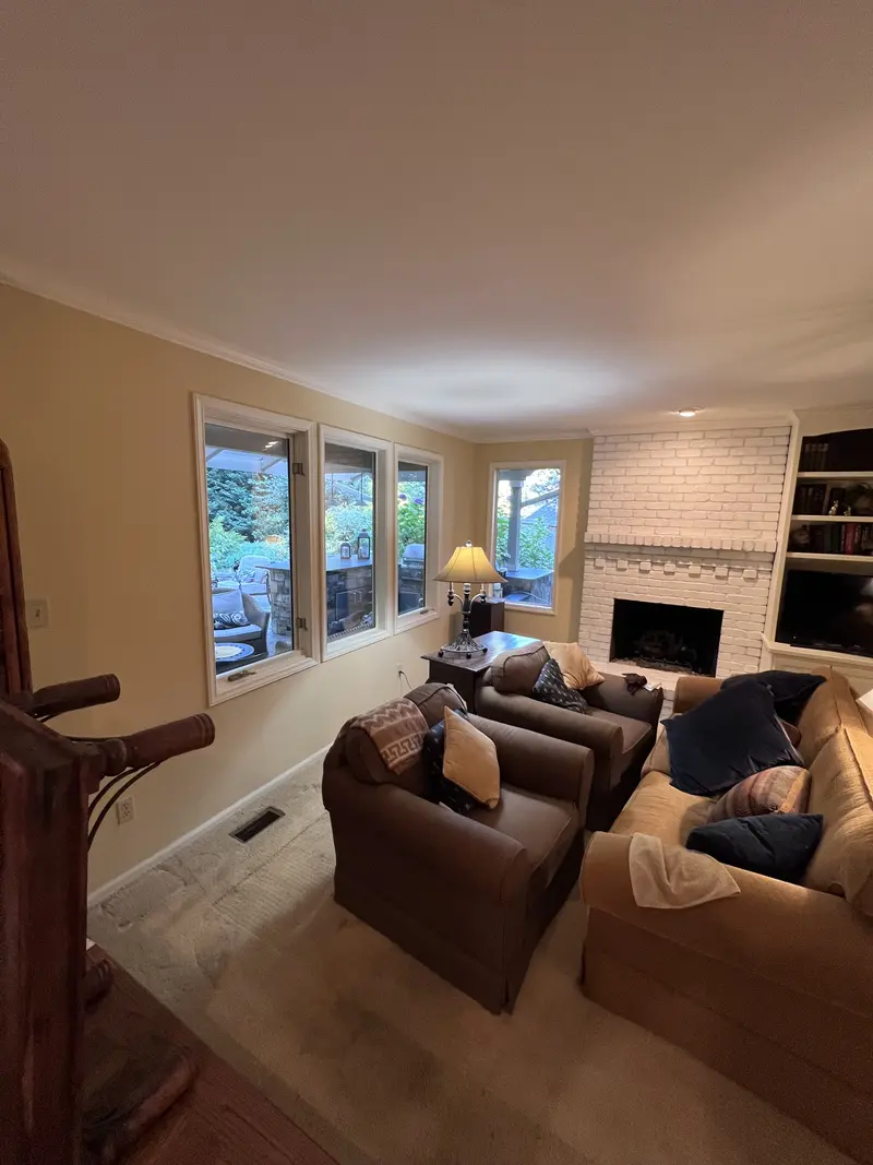 Living room with a row of windows to the garden and the white fireplace in the corner