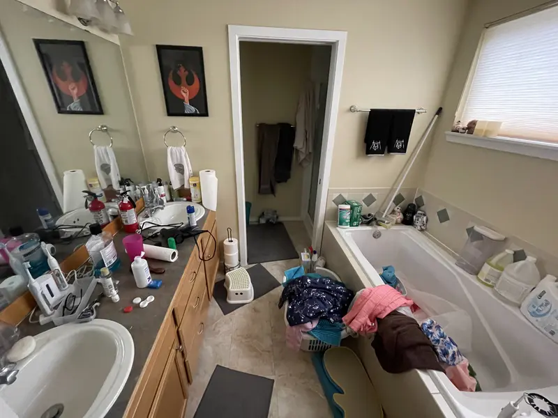 Master bathroom before the remodel with a drop-in tub under the window and an oak vanity
